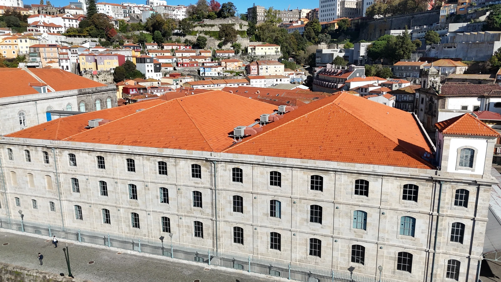 Vista aérea da Alfândega do Porto, na margem do Douro, com os telhados e a fachada em granito limpos pela AREALIMPA e a cidade ao fundo