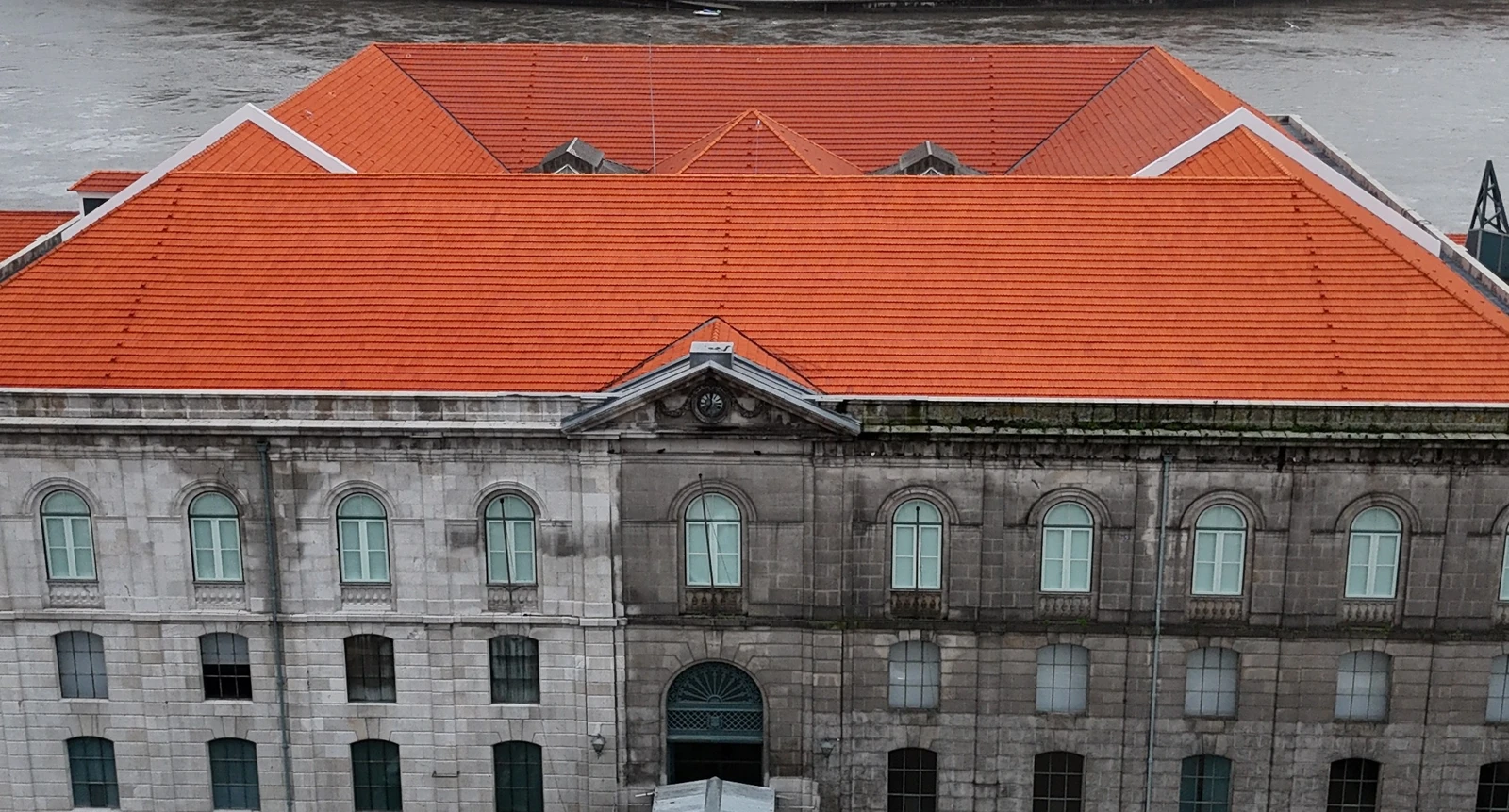 Vista de drone da fachada e do telhado da Alfândega do Porto antes da limpeza da AREALIMPA, com o granito escuro e manchado