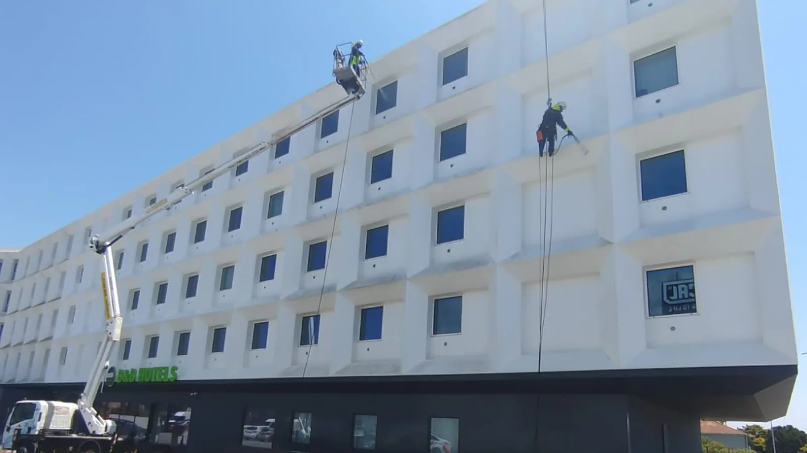 Hotel B&B Vila do Conde durante a lavagem da fachada branca, com plataforma elevatória em camião e trabalhos verticais