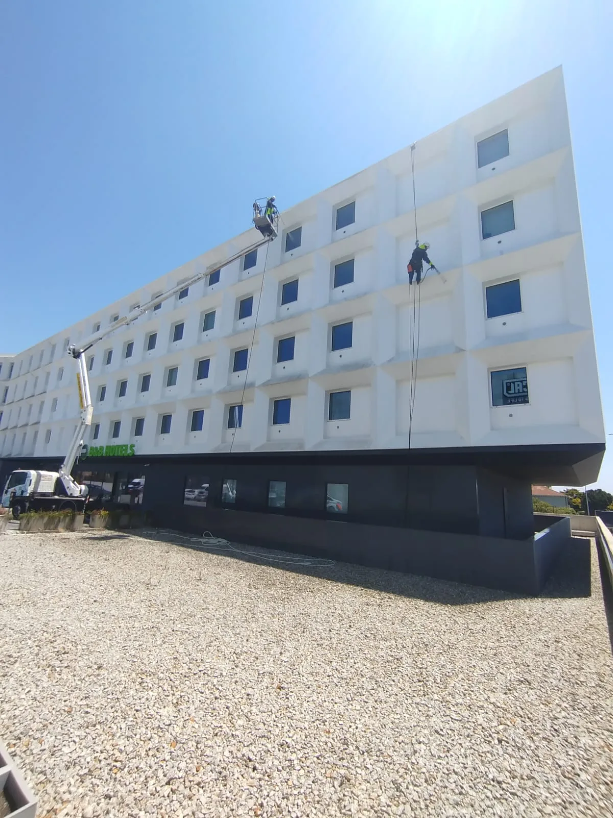 Lavagem da fachada do Hotel B&B Vila do Conde com plataforma elevatória em camião e trabalhos verticais junto à fachada branca