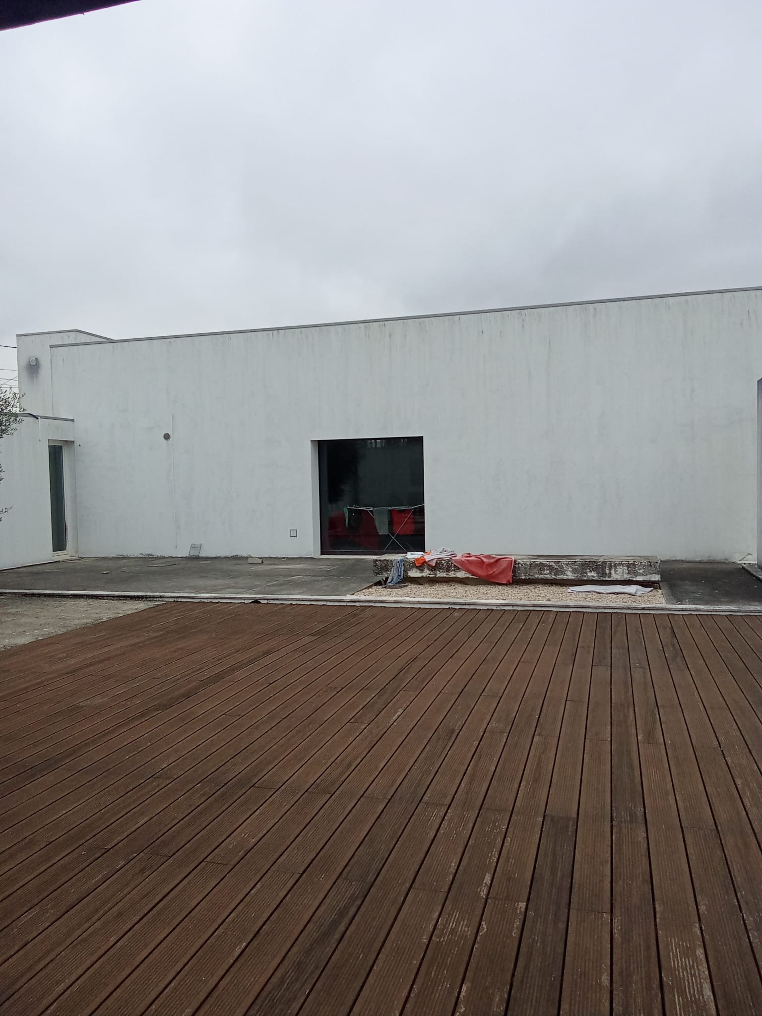 Fachada da moradia na Marinha Grande virada para o deck, antes da limpeza