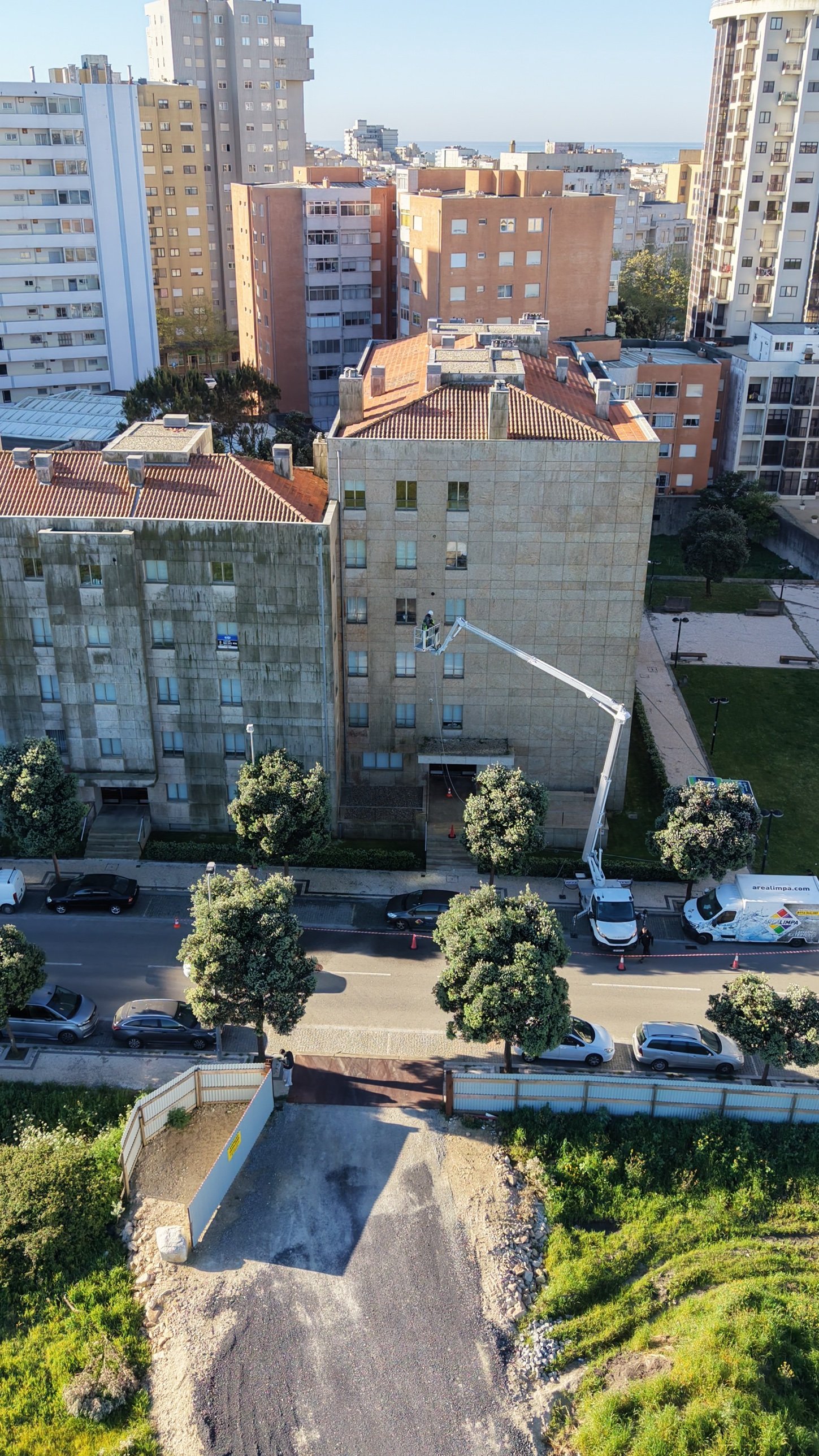 Plataforma elevatória da Arealimpa a limpar com SoftWash a fachada do Edifício Albatroz