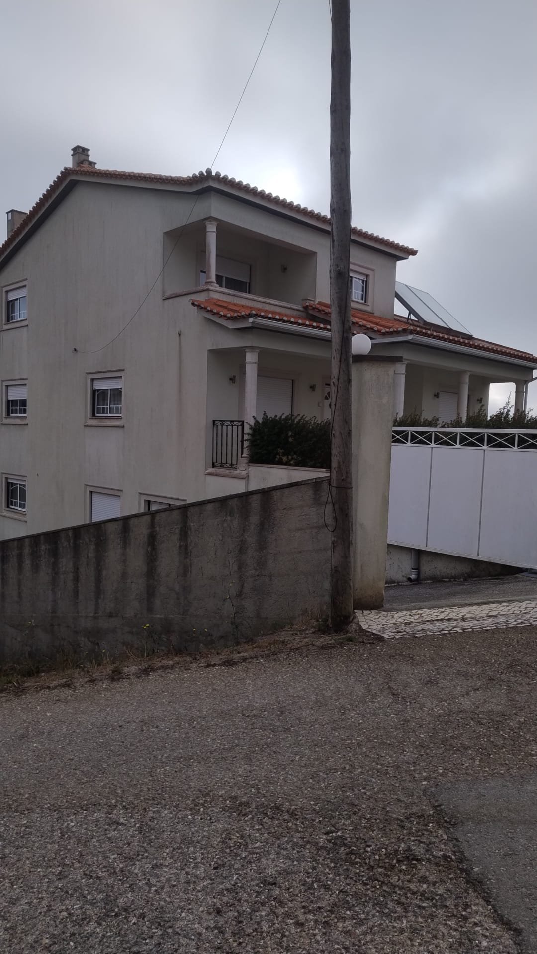 Lateral da moradia em Fátima e muro escuro antes da lavagem