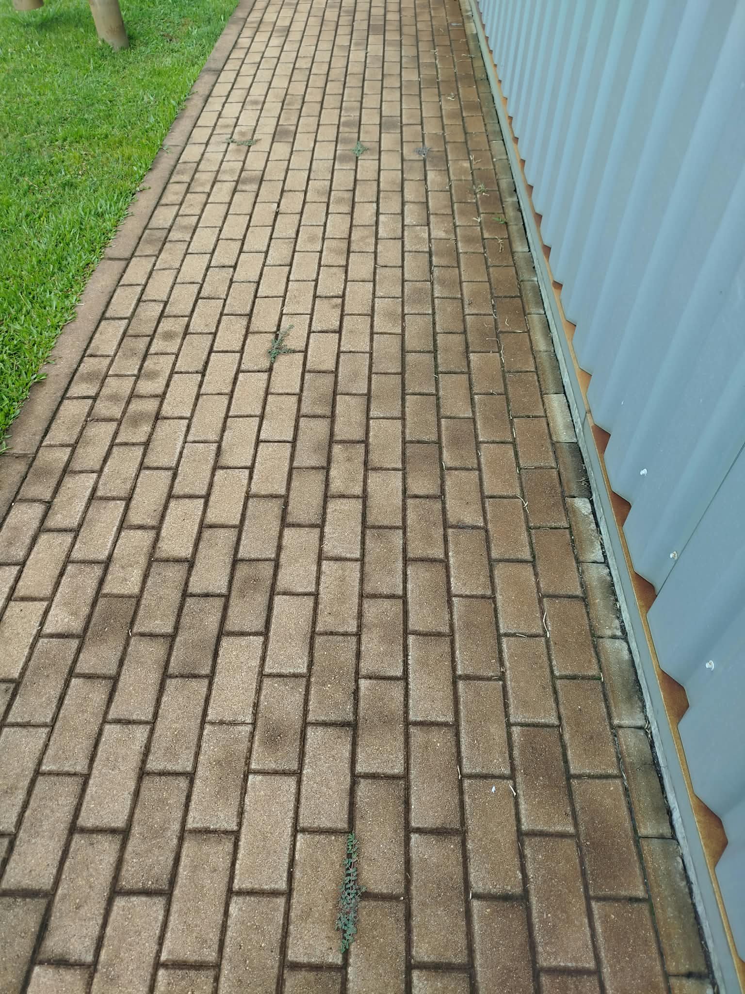 Passeio em blocos de betão escurecido junto ao pavilhão industrial em Santo Tirso