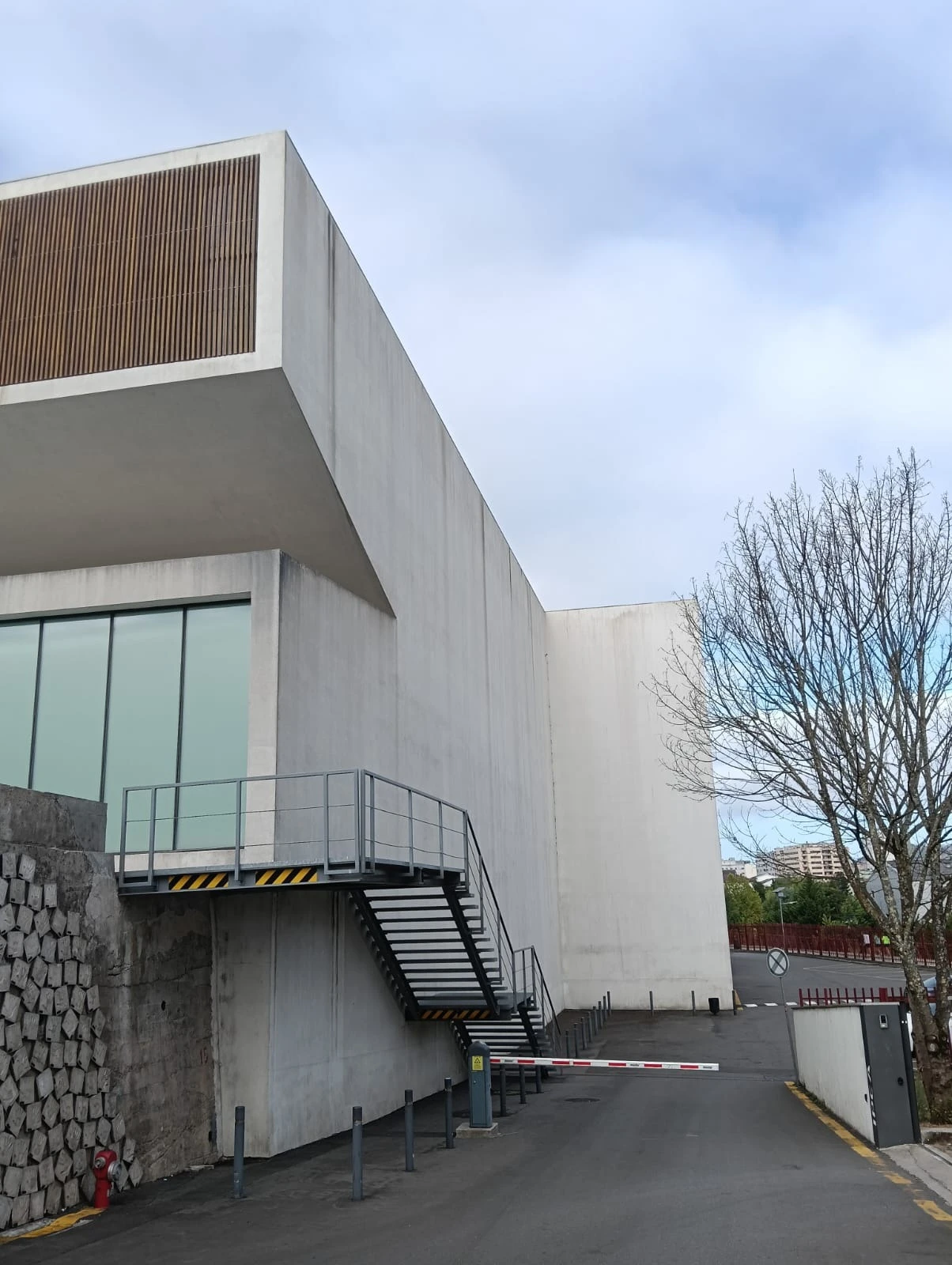 Fachada do Fórum Braga com escada metálica exterior e cancela, paredes acinzentadas, antes da lavagem SoftWash da AREALIMPA