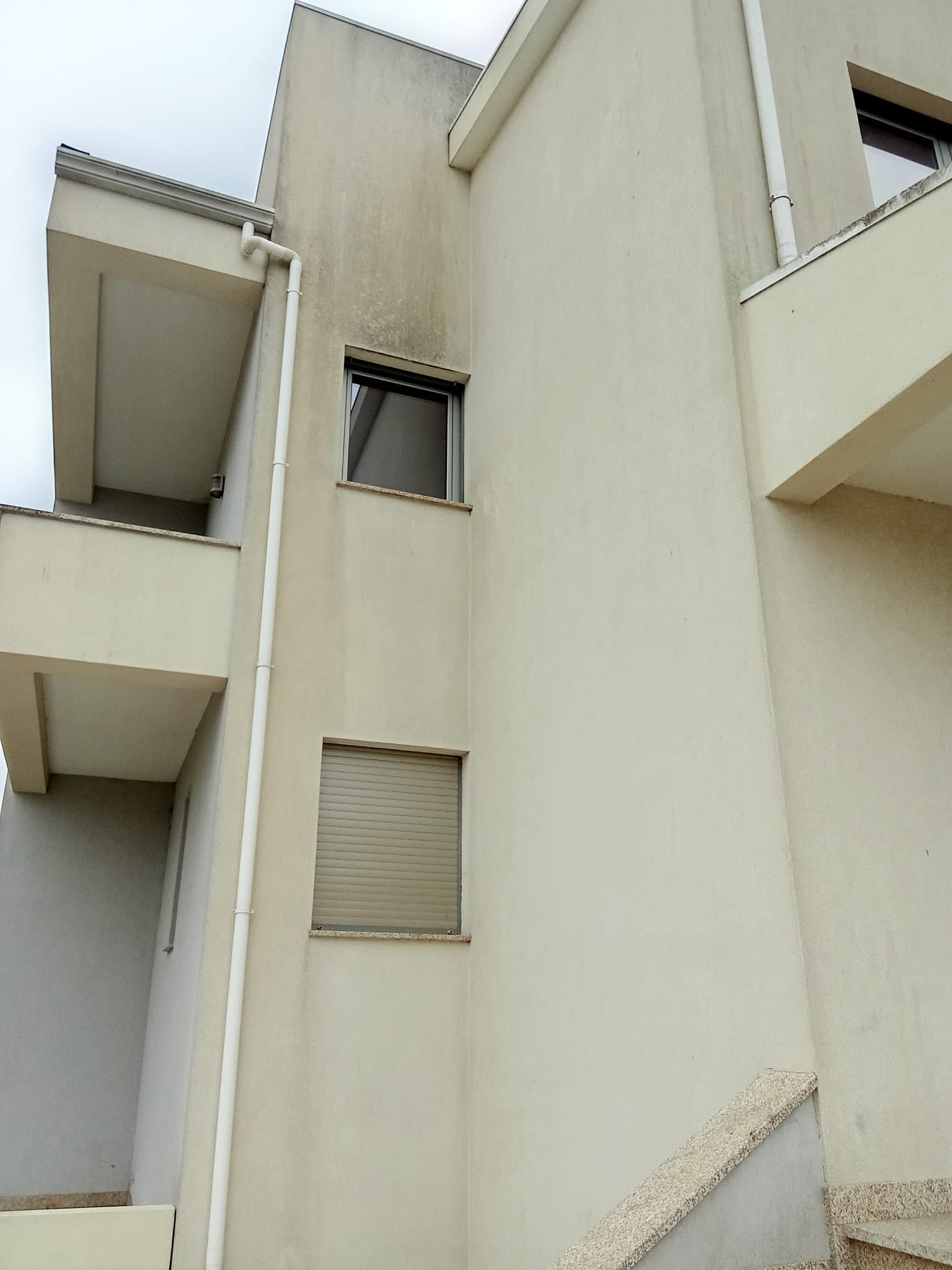 Fachada com janelas e escorrências na moradia em Gaia