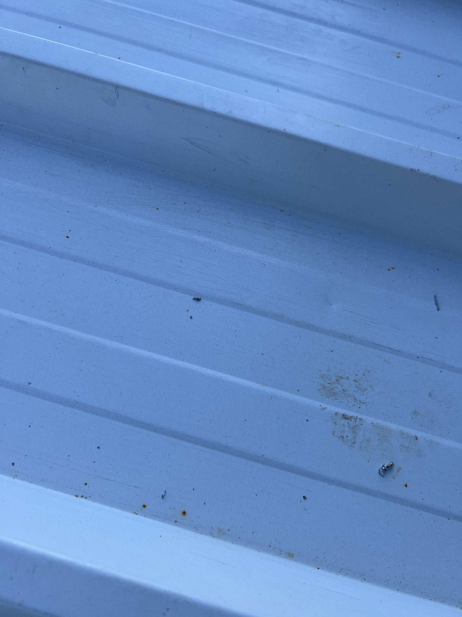 Pormenor da chapa da cobertura industrial em Aveiro com pontos de ferrugem provocados pela fuligem