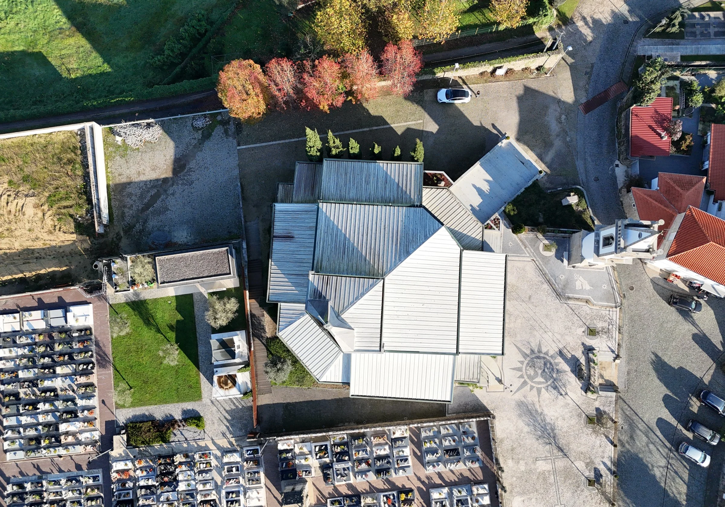 Vista aérea da Igreja de Brufe e do largo, antes da lavagem, com as coberturas metálicas escurecidas