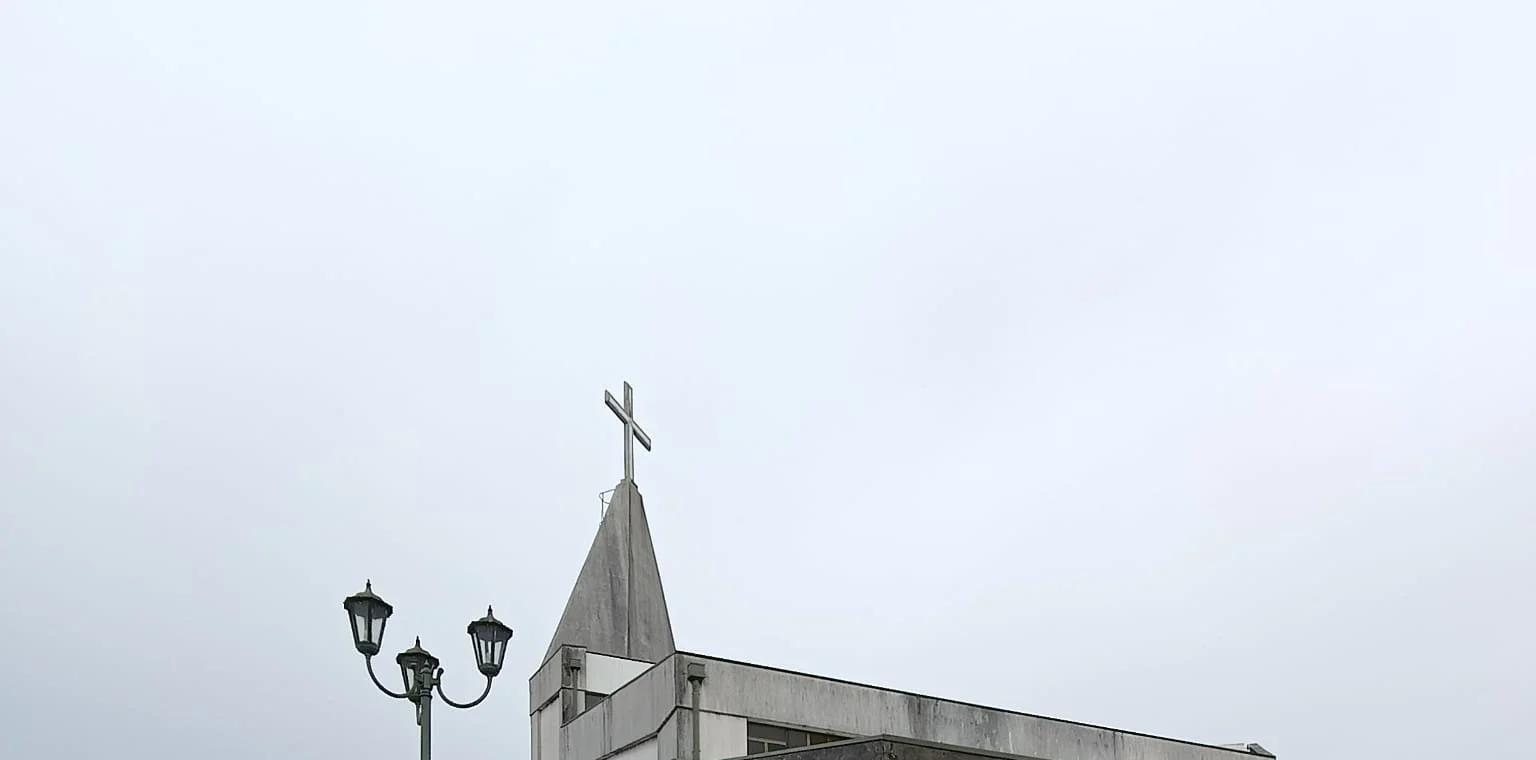 Frontão e fachada branca da Igreja de Brufe antes da lavagem, com escorrências escuras
