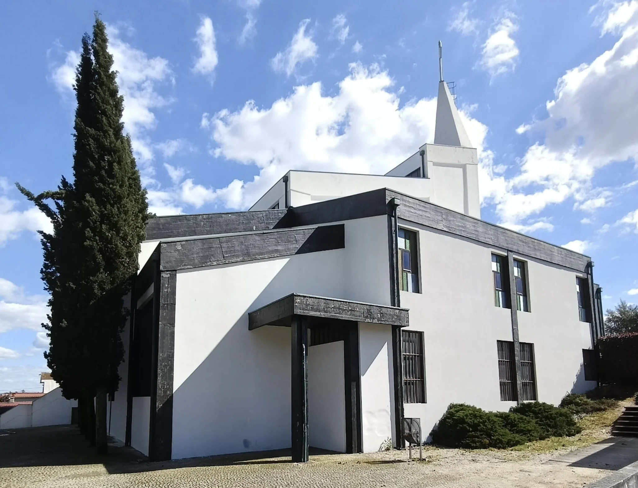 Fachada lateral da Igreja de Brufe depois da lavagem, com um cipreste em primeiro plano
