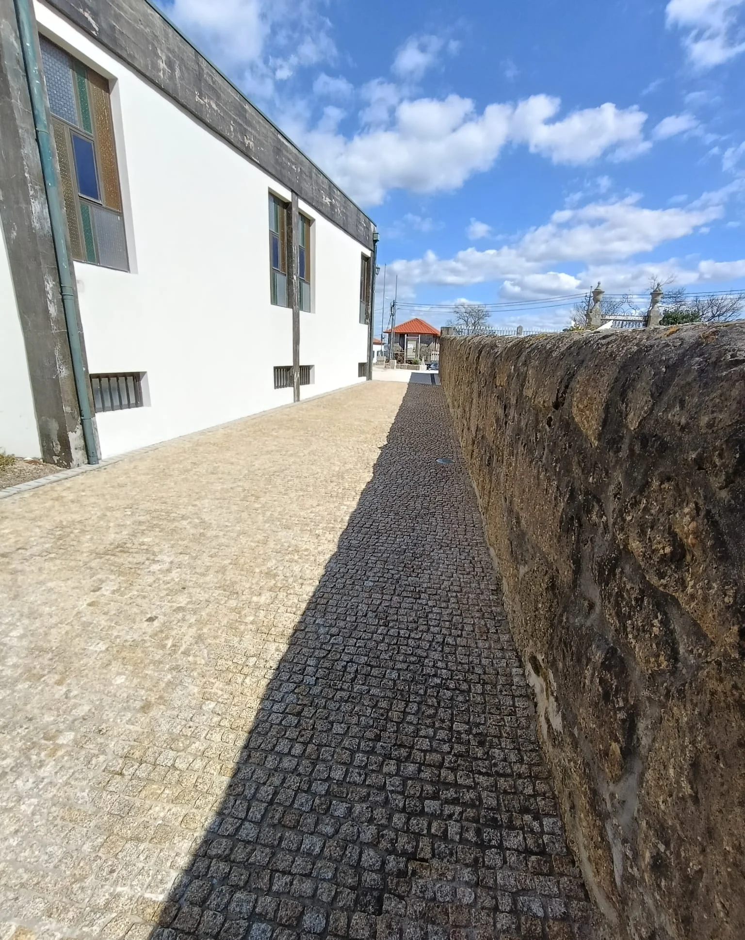 Pavimento de granito ao longo do muro de pedra da Igreja de Brufe, depois da lavagem