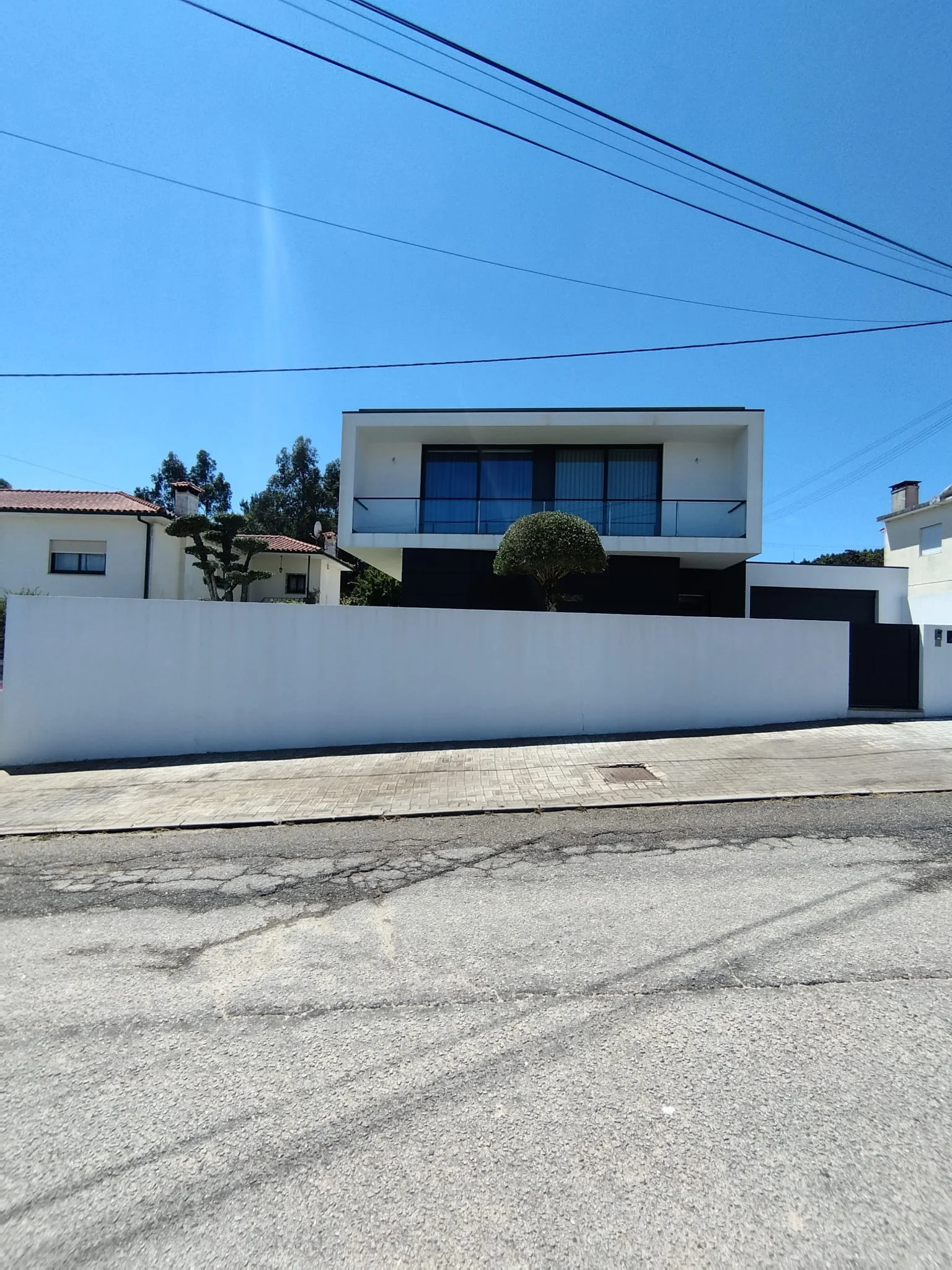 Muro da rua e frente da mesma moradia em Brufe, de novo brancos depois da lavagem
