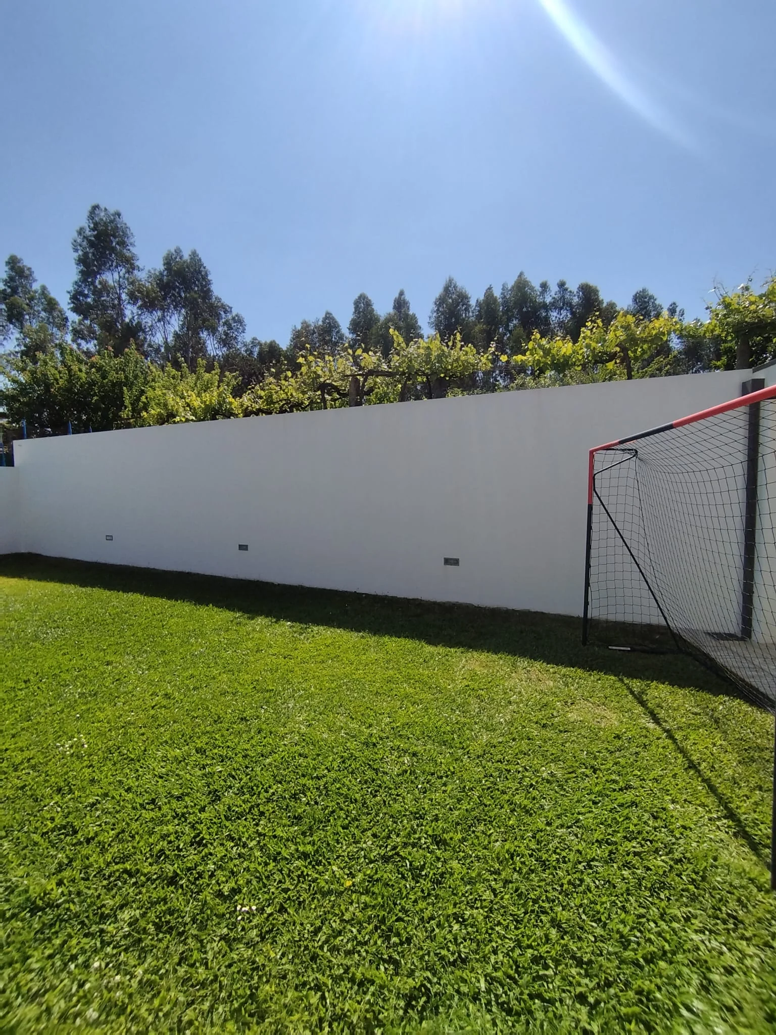 Muro do fundo da mesma moradia em Brufe sem as escorrências negras, depois da lavagem