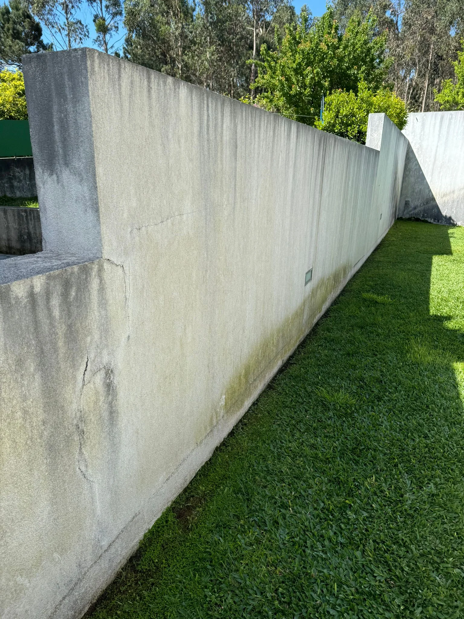 Muro lateral de uma moradia em Brufe escurecido em toda a extensão