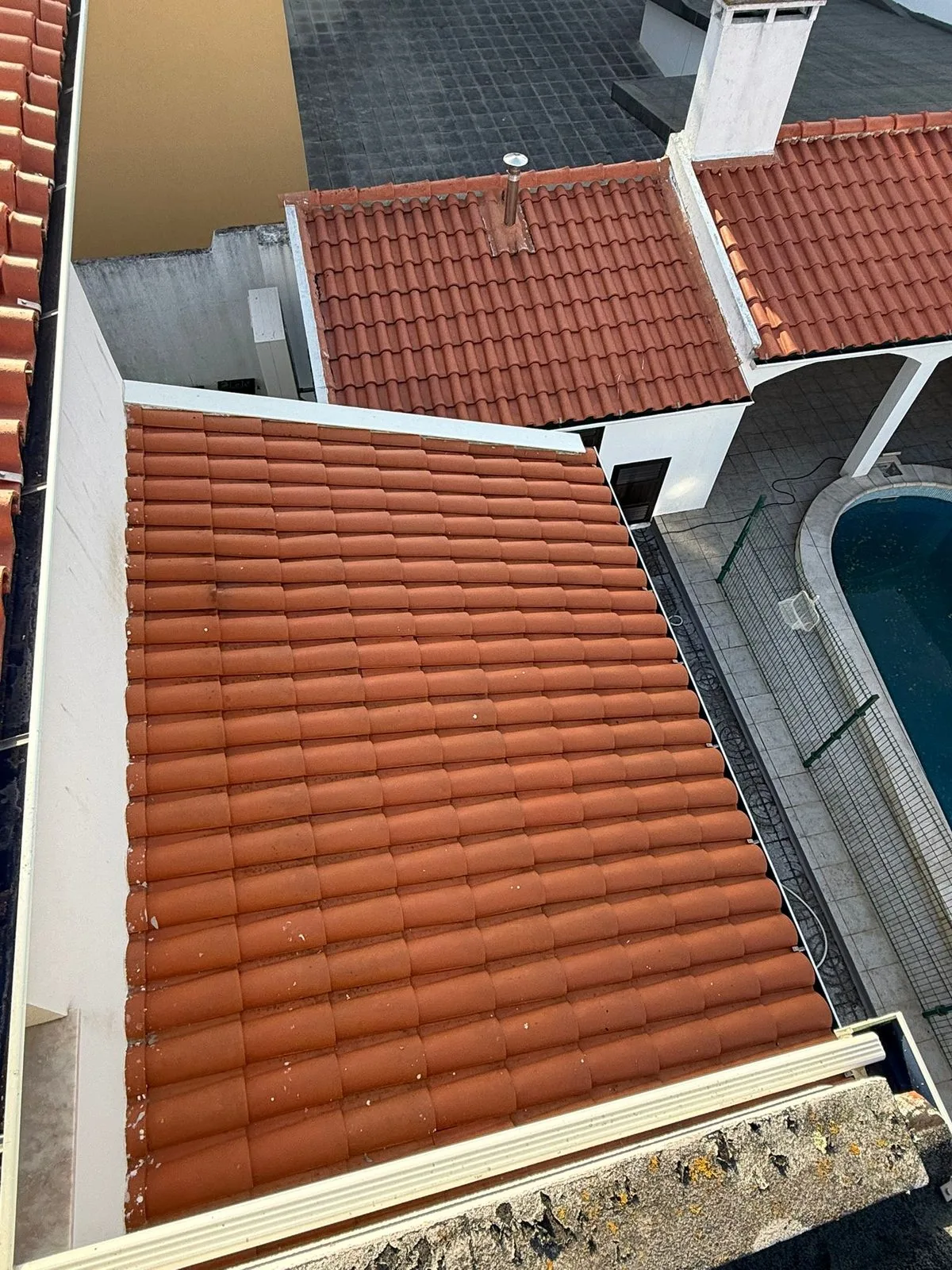 A mesma água de telhado na Figueira da Foz com a telha limpa e a cor de barro recuperada depois da limpeza SoftWash da AREALIMPA