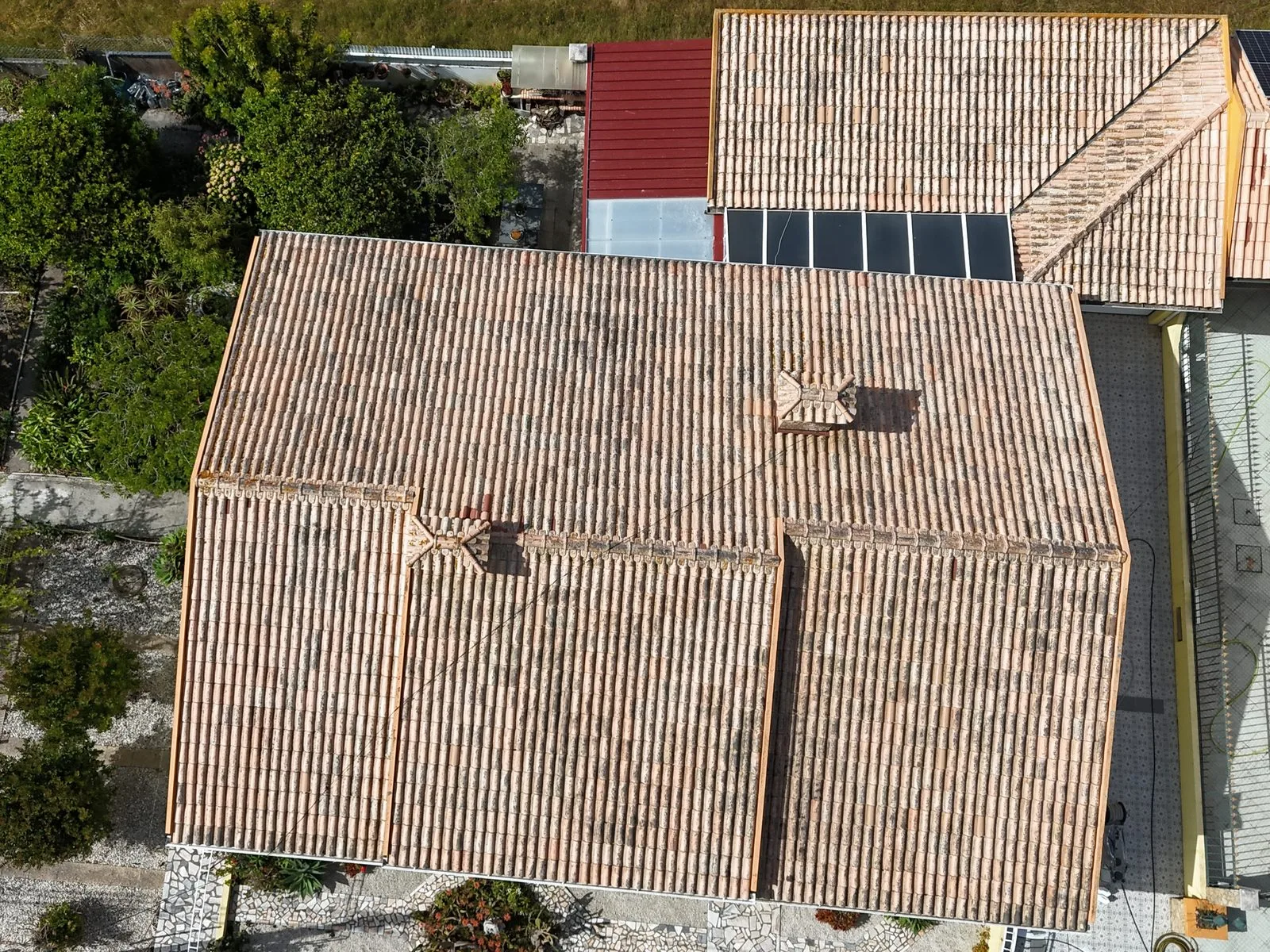 Vista de drone do telhado em telha cerâmica de uma moradia na Gafanha da Encarnação, Ílhavo, escurecido por fungos e líquenes antes da limpeza SoftWash da AREALIMPA