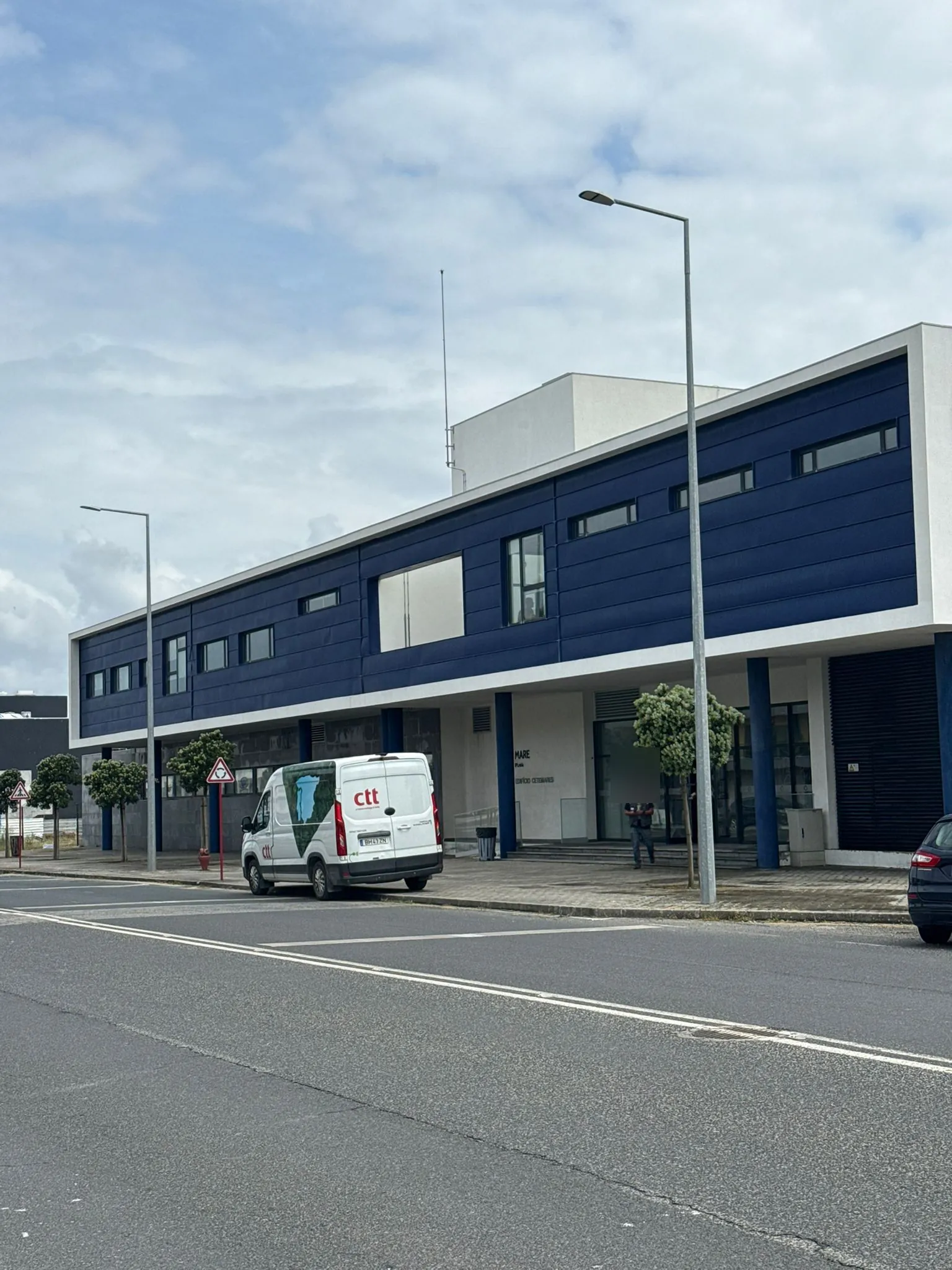 A mesma fachada longa com faixa azul do Instituto Politécnico de Leiria em Peniche, vista da rua, depois da limpeza da AREALIMPA