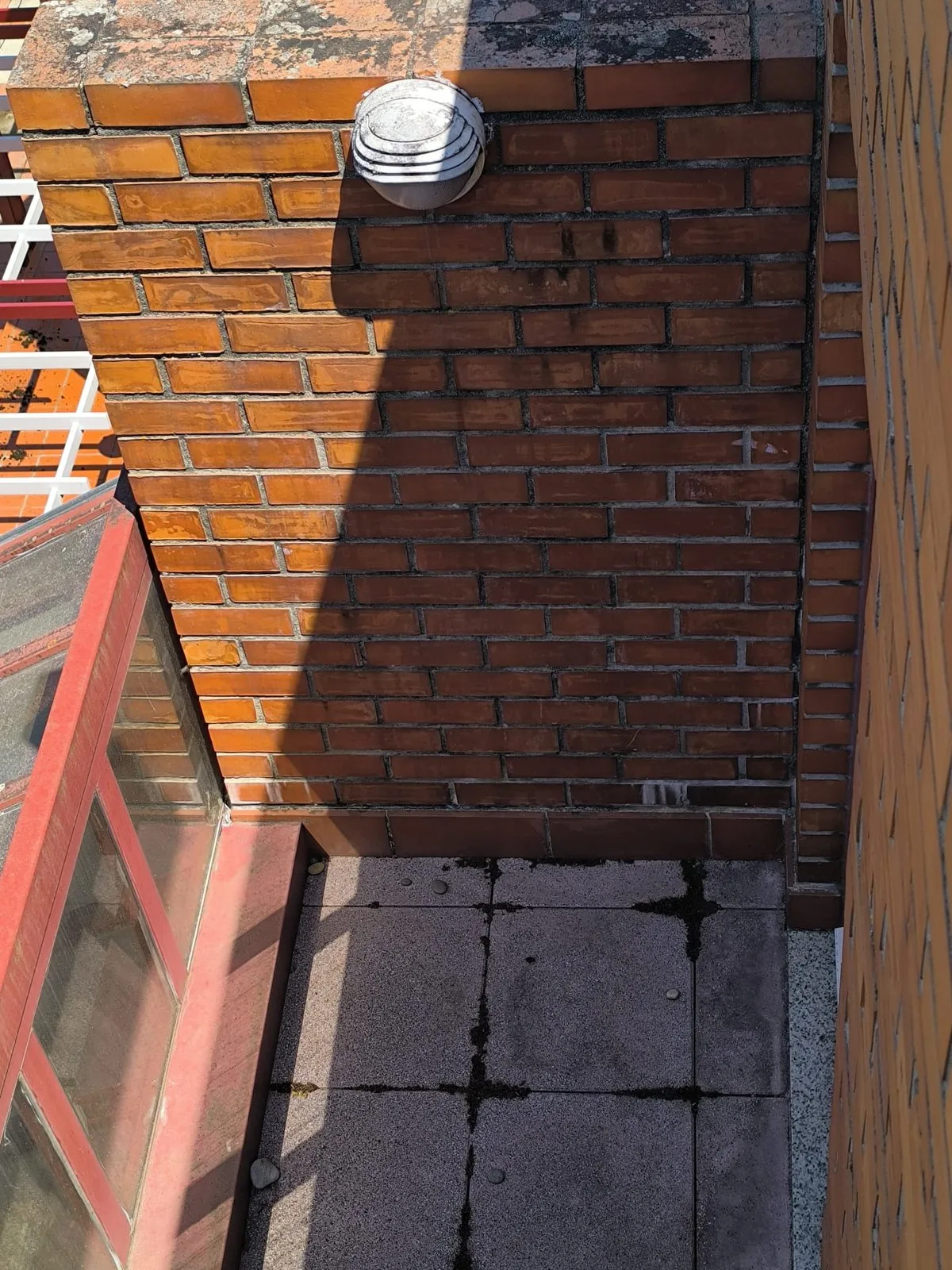 O mesmo muro de tijolo face à vista do saguão de um condomínio em Viana do Castelo, com a cor mais uniforme, depois da lavagem com SoftWash e do hidrófugo da AREALIMPA
