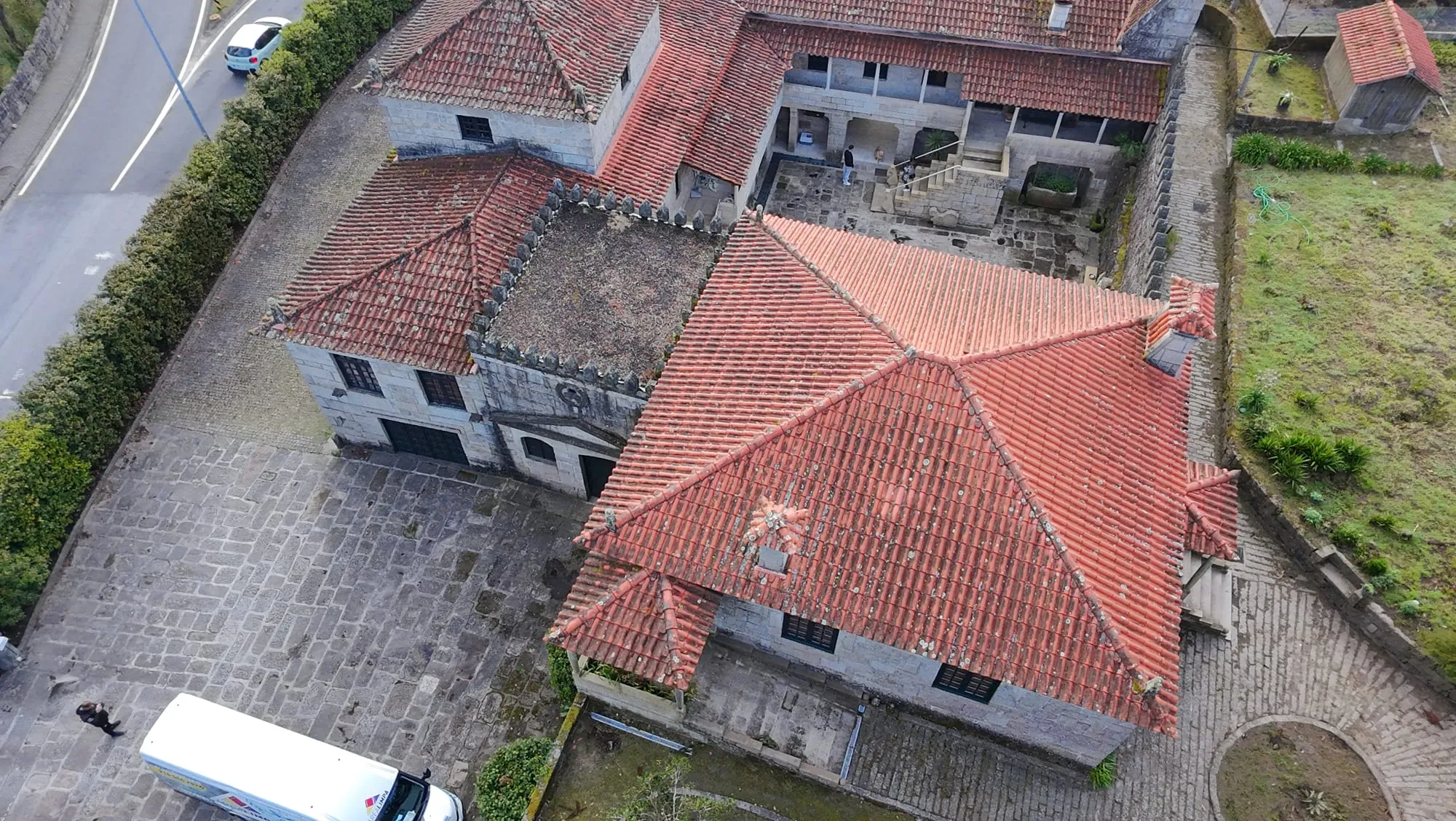 Vista aérea do telhado de telha cerâmica de um edifício em granito em Penafiel, com a telha escurecida, antes da limpeza da AREALIMPA