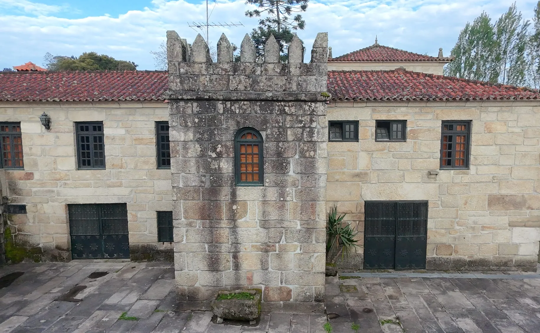 Torre ameada e fachadas em granito de um edifício em Penafiel, vistas de cima, com a pedra escurecida, antes da limpeza da AREALIMPA