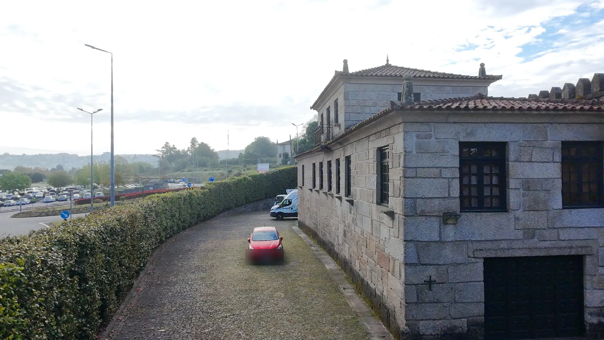 Acesso em cubos de granito escurecidos junto a um edifício em Penafiel, visto de cima, antes da limpeza da AREALIMPA