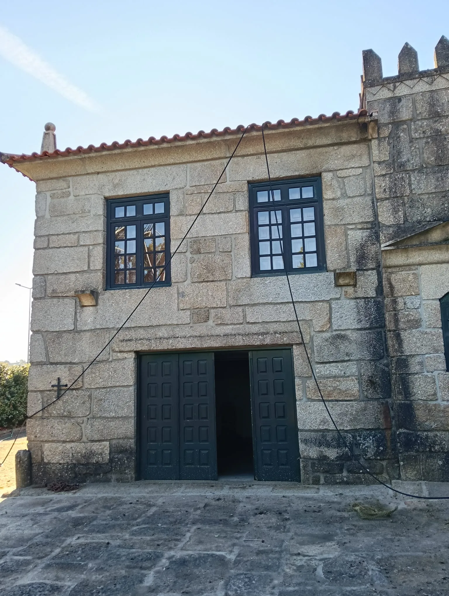 Frente em granito com portão de duas folhas de um edifício em Penafiel, com a pedra escurecida, antes da limpeza da AREALIMPA