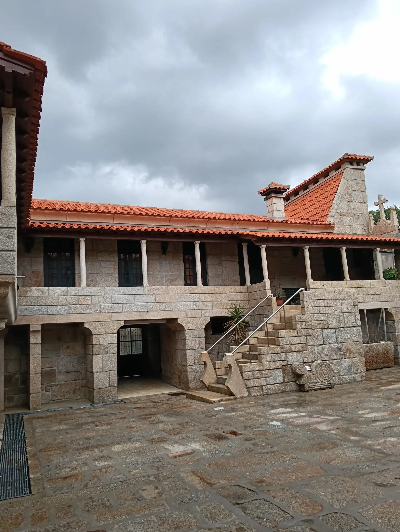 Alpendre em granito com colunas e escada de um edifício em Penafiel, depois da limpeza da AREALIMPA