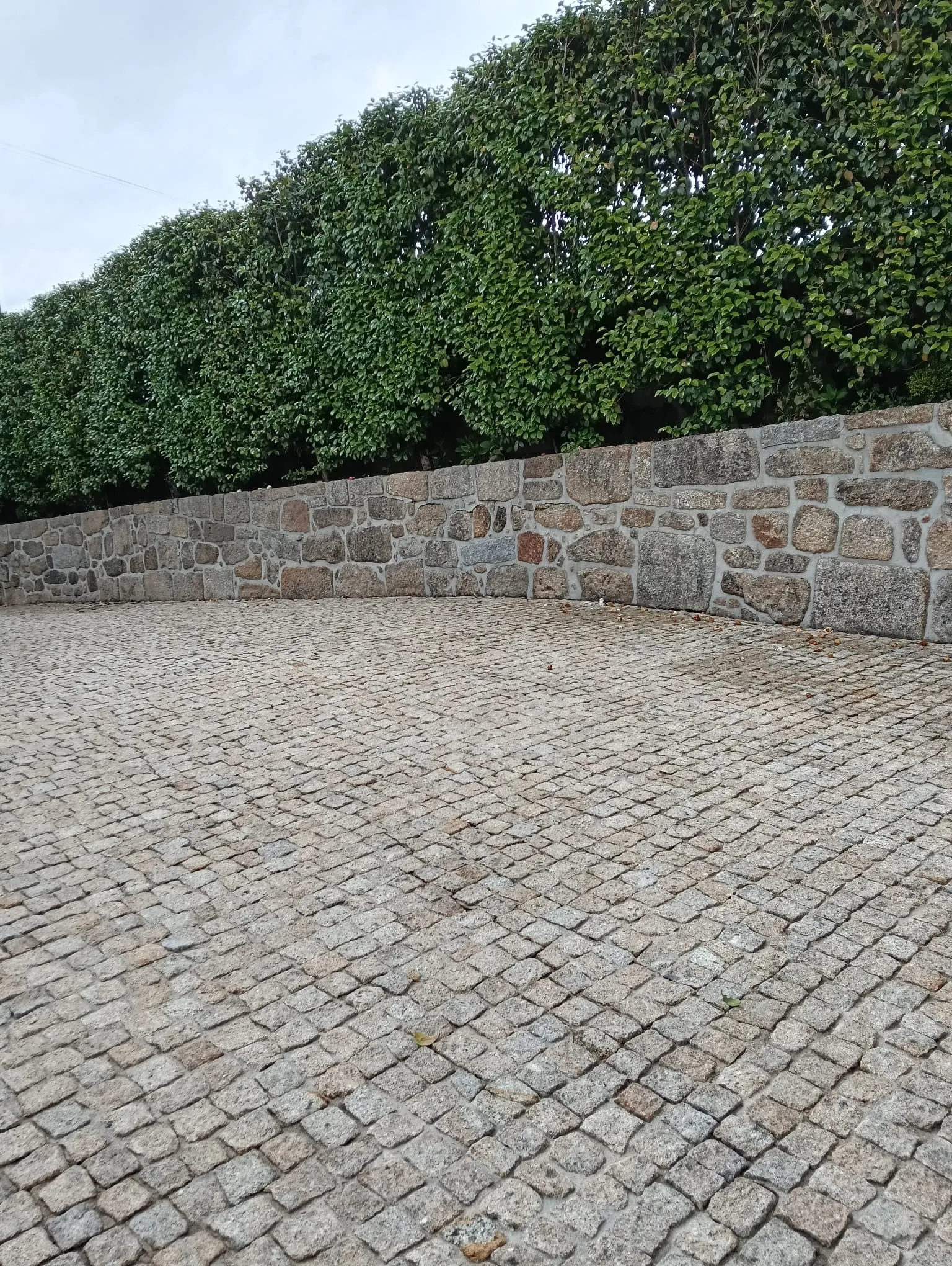 Pavimento em cubos de granito junto a um muro de pedra em Penafiel, depois da limpeza da AREALIMPA