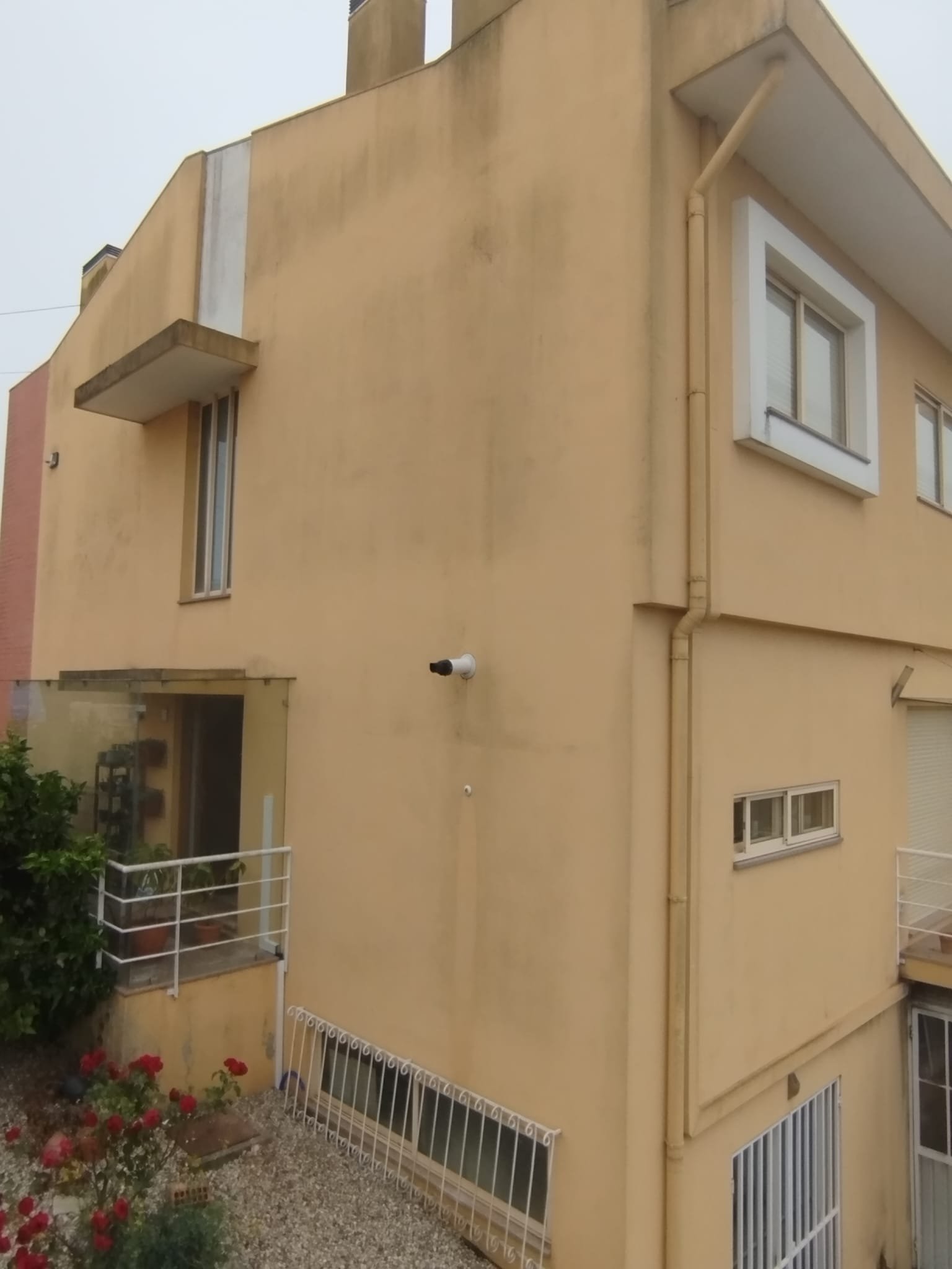 Empena em capoto amarelo de moradia em Ovar com escorrências escuras