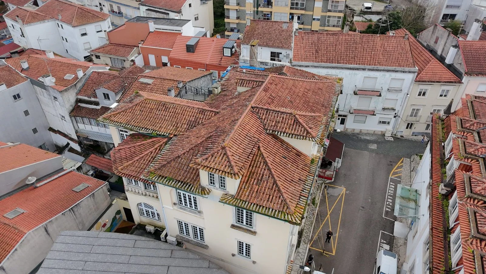 Vista de drone do telhado da Santa Casa da Misericórdia de Leiria antes da lavagem, com telhas escurecidas e musgo nos beirais