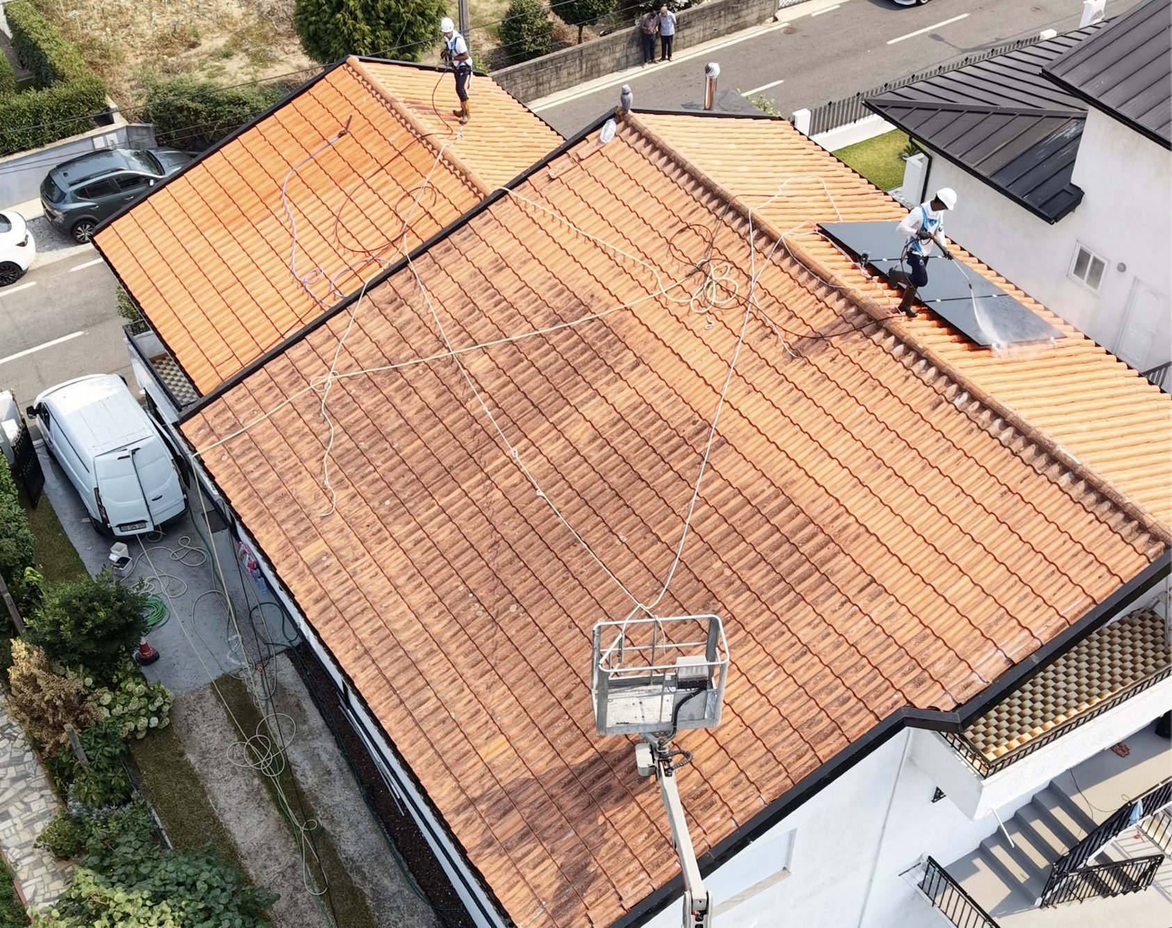 Operadores com linhas de vida a lavar o telhado em Santo Tirso, com plataforma elevatória